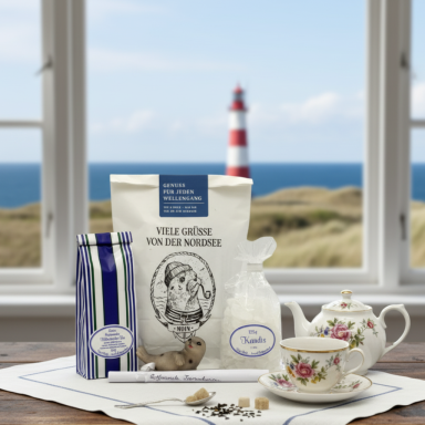 Teegeschenke Eine Teetasse, Keks, Teeverpackungen und ein Leuchtturm im Hintergrund.